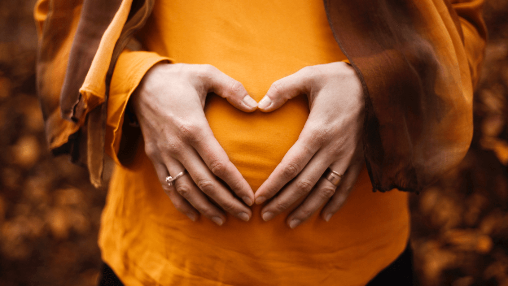 Frau hält ihren Babybauch fest: Finanzen in der Schwangerschaft